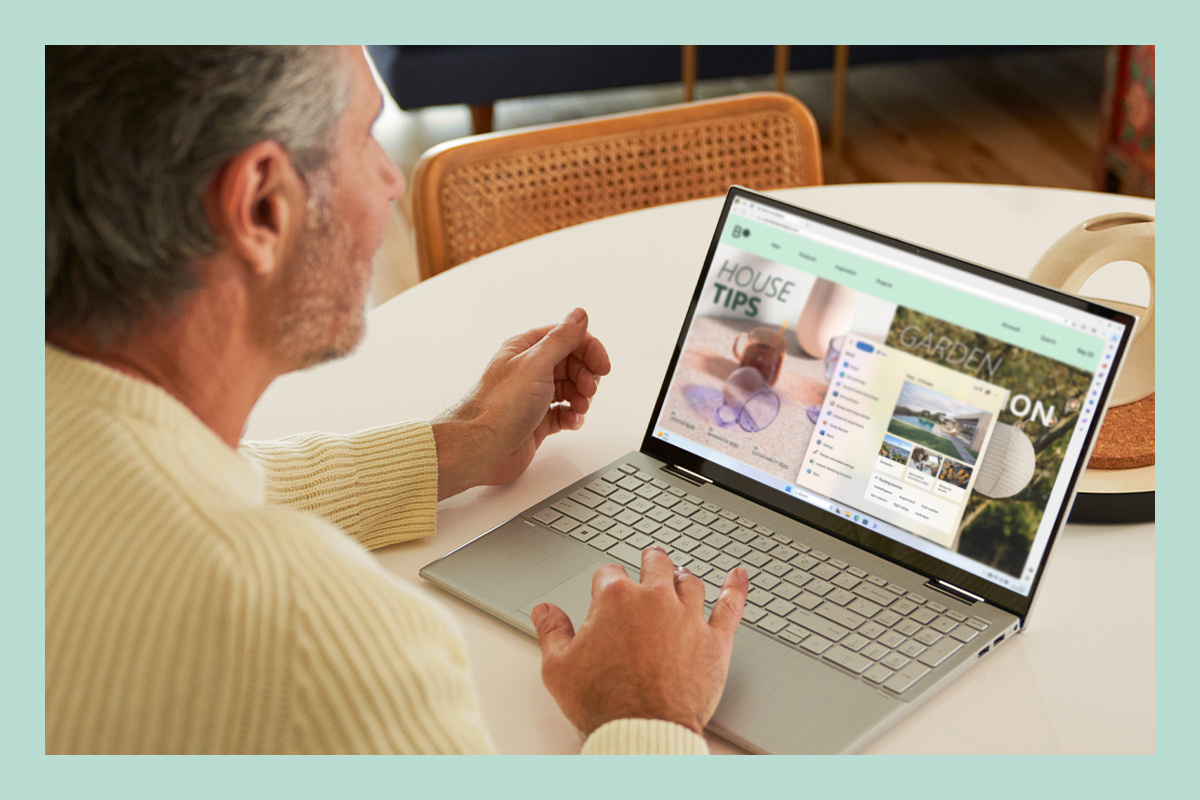 A man is working using a laptop with Windows 11.